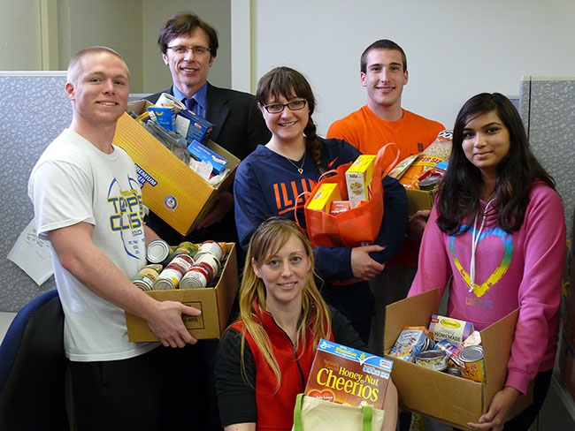 Dr. Notaro with his students, holding boxes of food