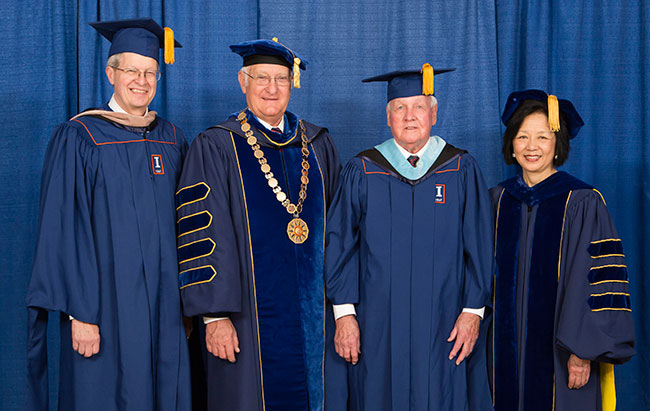 Dale Flach, dressed in cap and gown, flanked by University of Illinois President Robert Easter and Chancellor Phyllis Wise.
